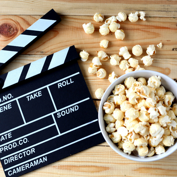 A photo of a movie clapperboard and popcorn. 